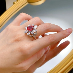 Close-up of a floral S925 silver ring with an oval red gemstone and white petal stones