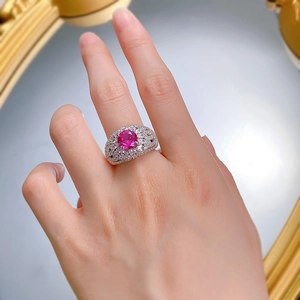 Gros plan d'une bague en argent S925 avec une grande pierre rose et anneau ajouré au doigt