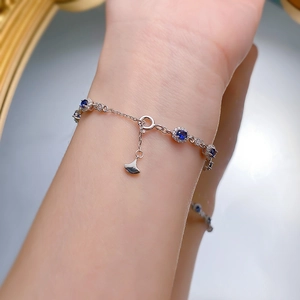 Detailed shot of an S925 silver bracelet featuring blue sapphires and ginkgo leaf charm