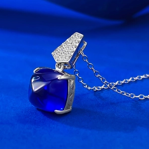 Détail macro du pendentif en pierre bleu royal taille pain de sucre et bélière sertie