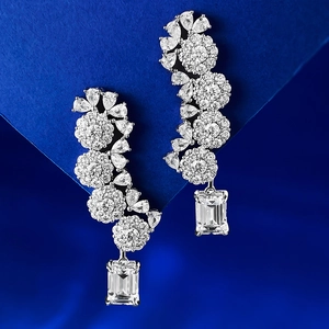 Luxurious S925 silver flower drop earrings with emerald-cut crystals on blue background