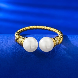 Close-up of golden twisted rope ring featuring two white pearls and zircon details