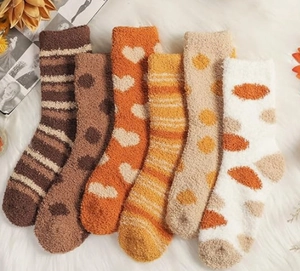 Close-up of 6-pair fluffy coral fleece warm socks in various winter patterns and colors