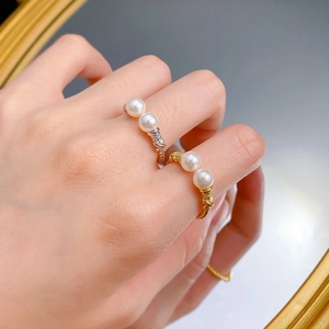 Detail of twisted s925 silver pearl rings with pavé accents worn on hand