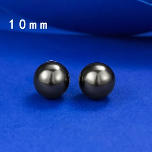 Detailed macro view of 10mm round black pearl earrings with high mirror luster finish