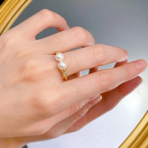 Detail of a 18K gold twist ring featuring dual 6mm pearls and micro zircon accents