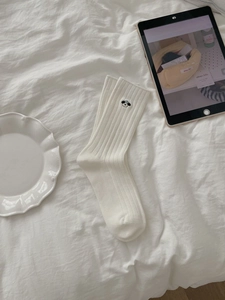 Details von weißen gerippten Baumwollsocken mit süßer Panda-Stickerei in Heimatmosphäre