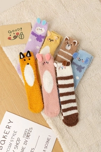 Détail de chaussettes en molleton corail avec oreilles d'animaux 3D sur tapis doux