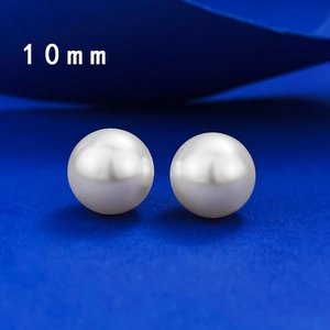 Macro shot of 10mm round white pearl earrings with high luster on dark background