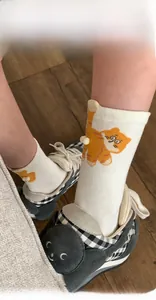Detail of white cotton socks with cute cat ears, orange stripes, and seamless toe design