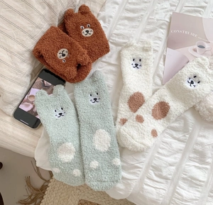 Detail of coral fleece bear socks showing 3D ears and soft embroidered animal faces