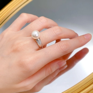 Macro detail of 10mm white shell pearl ring with silver band and zircon accents