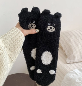 Detail of soft black coral fleece socks with 3D bear ears and cute white paw embroidery