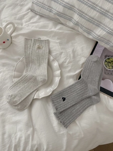 Details von Strick-Socken mit Wellensaum, Herzbestickung und gewebtem Logo-Etikett