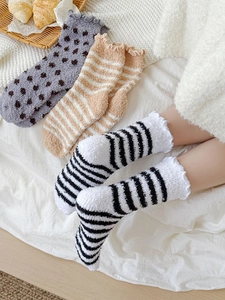 Detail of ruffled cuff coral fleece winter socks in striped and polka dot patterns