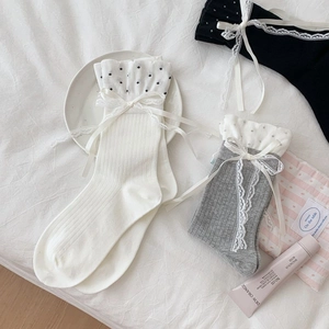 Detailed flat lay of lolita style socks with polka dot ribbons and lace trim in three colors
