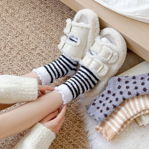 Close-up of cozy striped coral fleece socks with ruffled edges and plush slippers
