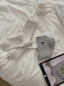Details von Baumwollsocken mit Herz-Stickerei und modischen Webetiketten-Akzenten