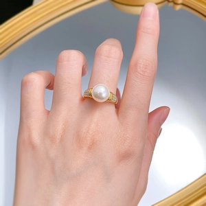 Detail of 10mm white shell pearl ring with textured gold band and micro zircon accents