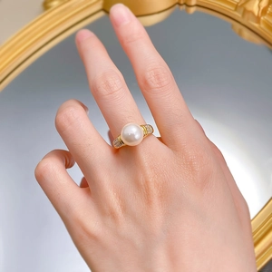 Detailed close-up of 10mm white pearl ring with gold diamond-set band on model's hand