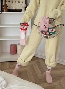 Detailed texture of pink coral fleece socks featuring a cute cartoon beaver design