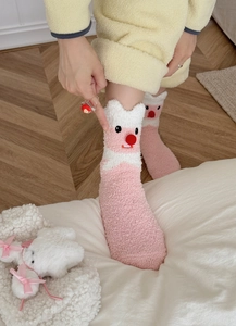 Close-up of pink coral fleece socks featuring cute cartoon beaver design for cozy home wear