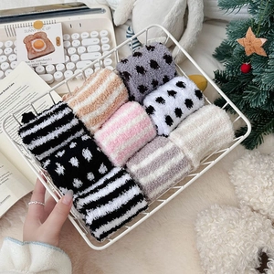 Detail view of colorful striped coral fleece socks in a cozy winter storage basket