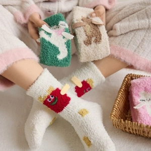 Close-up of thick coral fleece socks with cute cartoon 3D animal patterns for winter