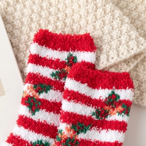 Detail of red and white striped Christmas socks in thick coral fleece on a knit blanket