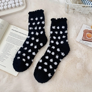 Close-up of black and white polka dot coral fleece socks with ruffled wood ear cuffs