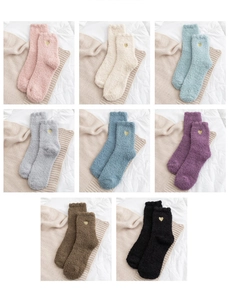 Flat lay of colorful coral fleece socks with gold heart embroidery for winter
