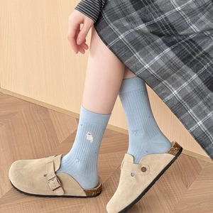 Détail de chaussettes en coton bleu clair avec broderie chat et motifs nœuds