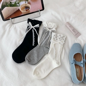 Close-up of three-pair sock set with polka dots, ruffles and white lace bows