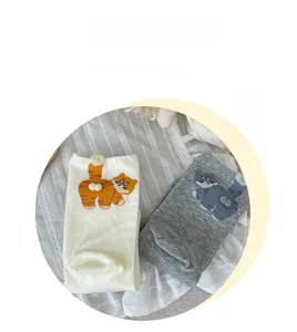 Detail of cute cat socks with 3D plush pom-poms on premium combed cotton fabric