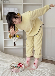 Close-up of thick yellow coral fleece loungewear with plush cartoon beaver socks