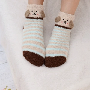 Détail de chaussettes en polaire corail avec rayures bleues et tête de chien en 3D
