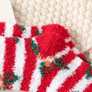 Close-up of soft red and white striped coral fleece Christmas socks with festive patterns