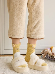 Détail de chaussette en polaire corail jaune avec oreilles 3D et pantoufle en peluche