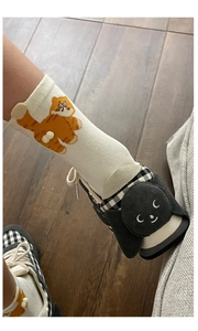 Close-up of cute cartoon cat socks with matching black and white checkered sneakers
