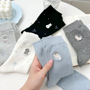 Détail de chaussettes en coton doux avec broderie animalière et texture côtelée