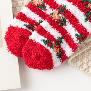 Close-up of fluffy red and white striped Christmas socks with festive floral patterns