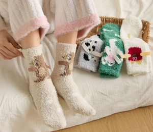 Detail of assorted 3D cartoon coral fleece socks featuring plush bear and cat patterns