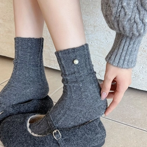 Détail de chaussettes en laine côtelée gris foncé avec perle et tricot chaud et doux