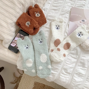 Detailed plush coral fleece socks with 3D animal ears on soft white bedding