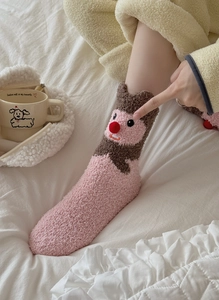 Detail of pink coral fleece socks featuring a 3D cartoon animal with a red plush nose