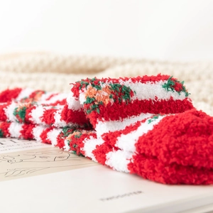 Detail of red and white striped coral fleece Christmas socks with soft floral patterns