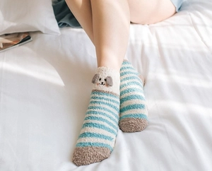 Détail de chaussettes en polaire corail à rayures bleues et blanches avec décor de chien