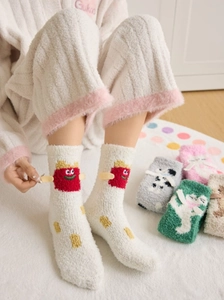 Detail of plush coral fleece socks featuring cute cartoon fry patterns for winter warmth