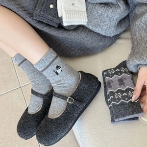 Détail de chaussures Mary Jane grises et chaussettes en tricot avec broderie chat et flocons