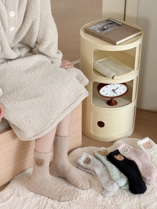 Detail of coral fleece winter socks with cute cartoon animal patches and plush texture